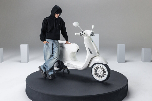 Justin Bieber standing next too the Vespa he helped to design.