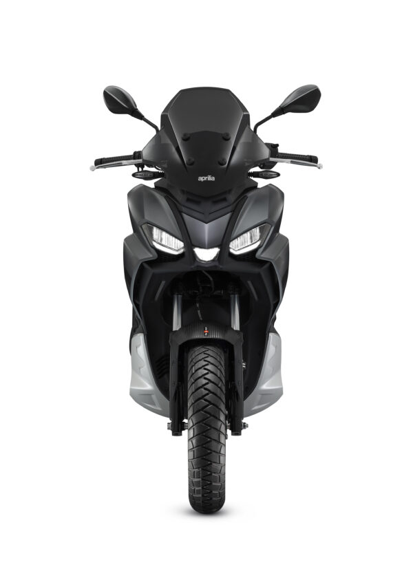 A front view of a black Aprilia motorcycle against a white background, showcasing its dual headlights, front wheel, and mirrors.