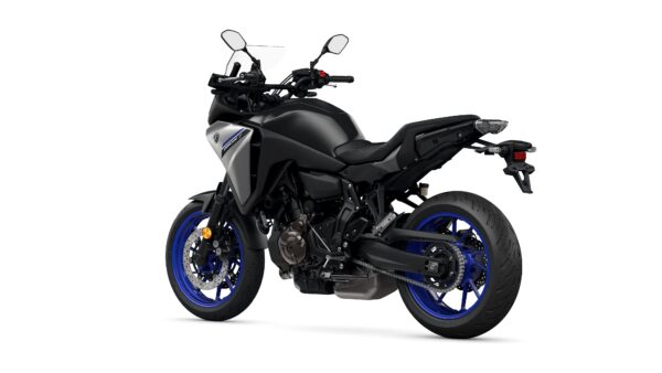 A sleek black motorcycle with blue rims, viewed from the rear-left angle, showcasing its modern design, dual-sport tires, and handlebar controls.