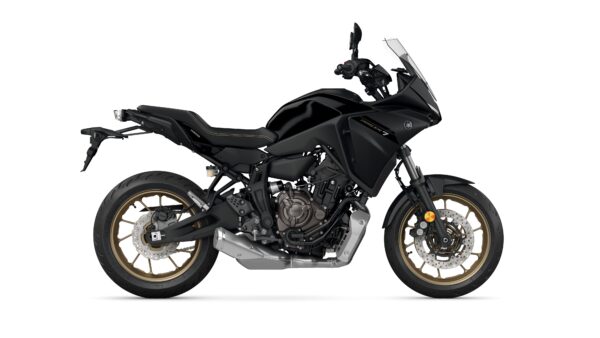 A side view of a black Yamaha Tracer 7 motorcycle, featuring a sleek design, gold-accented wheels, and a windshield.
