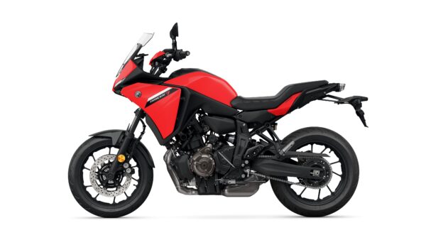 A red Yamaha Tracer 7 motorcycle is shown from the side, featuring a sporty design, a prominent windshield, and dual sport tires. The bike has a sleek frame and a minimalist tail section.