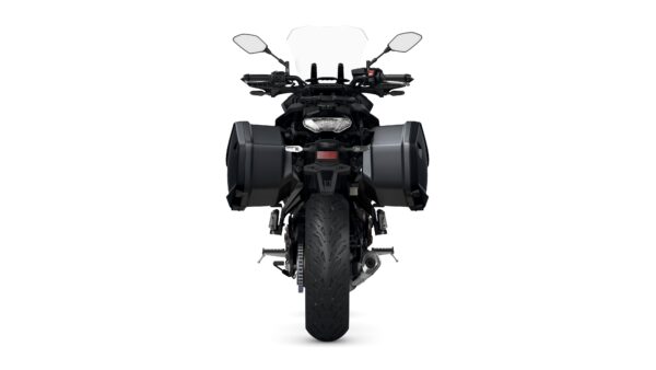 A front view of a motorcycle with a black frame, equipped with saddlebags on either side, a windshield, and visible handlebars. The rear tire features a tread pattern, and the motorcycle's lighting and detailing are clearly visible.