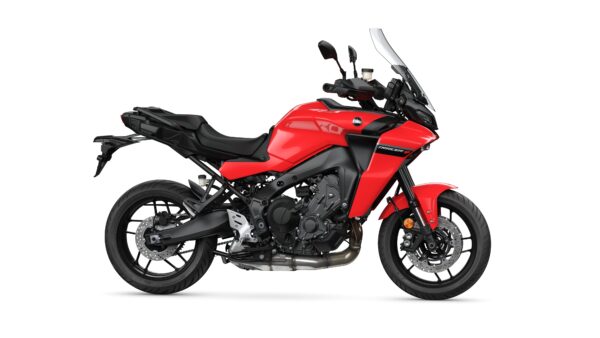 A red sport touring motorcycle featuring a sleek design, dual headlights, and a prominent windscreen, viewed from the side against a white background.