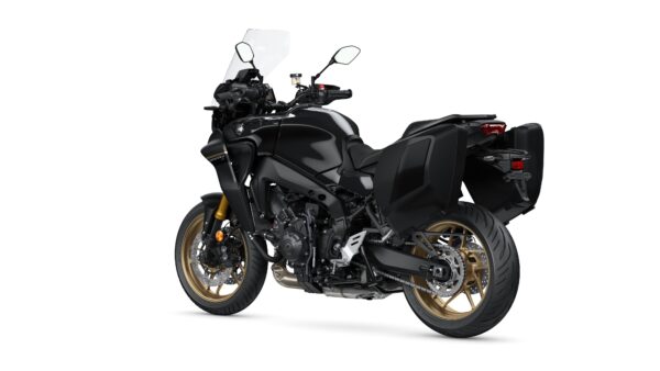 A sleek black motorcycle with gold wheels, side panniers, and a tall windscreen, angled to highlight its design and features.