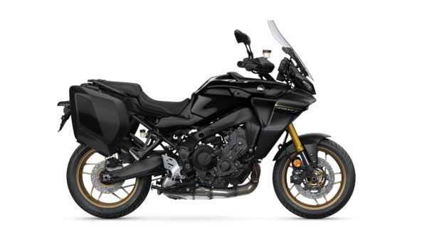 A sleek, black adventure motorcycle with gold accents, featuring saddlebags and a prominent windshield, positioned on a white background.