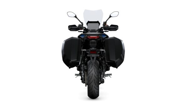 A rear view of a motorcycle with a prominent tire and black side panniers, featuring a clear windscreen, handlebars with mirrors, and a small display panel.