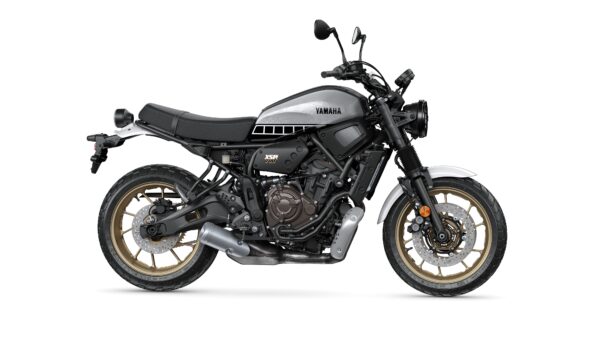 A Yamaha XSR700 motorcycle in a sleek black and silver color scheme, featuring an exposed frame and gold-accented wheels, stands on a white background.