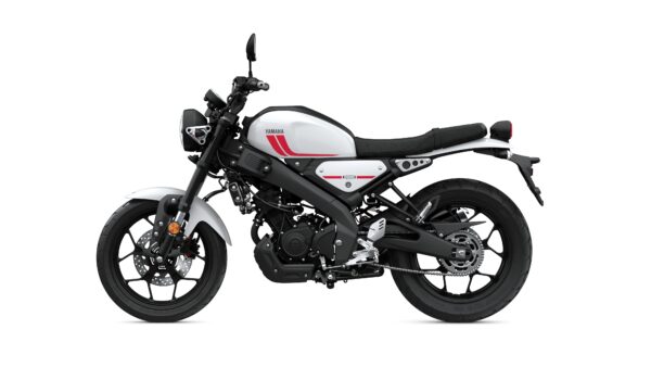 A sleek white and black Yamaha motorcycle with red accents, viewed from the side, showcasing its modern design and circular headlight.