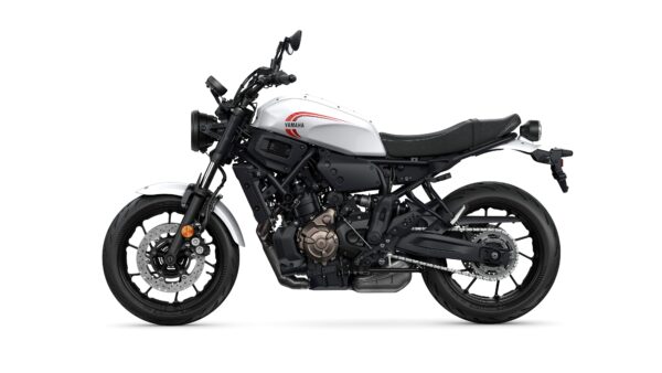 A white and black Yamaha motorcycle is displayed in profile, showcasing its sleek design, round headlight, and modern features, with a visible engine and detailed wheels.