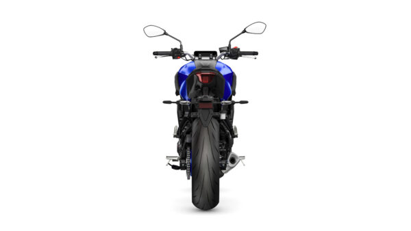 A rear view of a blue motorcycle with a large rear tire, showing the tail light, exhaust, and handlebars.