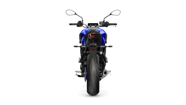 A rear view of a blue motorcycle with a prominent rear tire and distinctive tail light, showcasing the handlebars and mirrors.