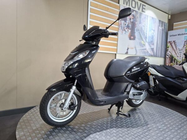 A black scooter is displayed on a circular platform, showcasing its sleek design. The background features a modern interior with urban-themed graphics.