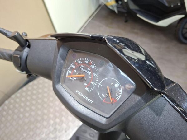 A close-up view of a Peugeot scooter's dashboard, displaying the speedometer and fuel gauge, with a mileage reading of 14,552 kilometers. The handlebars and controls are partially visible in the frame.