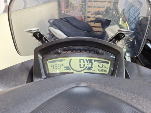 Digital motorcycle dashboard displaying a clock showing 9:59, speedometer at 0 MPH, outside temperature at 21°C, and odometer reading 36,800.