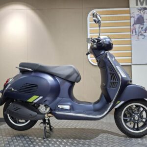 Vespa GTS 310 Supertech (2025) A blue Vespa scooter displayed against a neutral backdrop, featuring a sleek design with a prominent front headlight, stylish wheels, and a glossy finish.