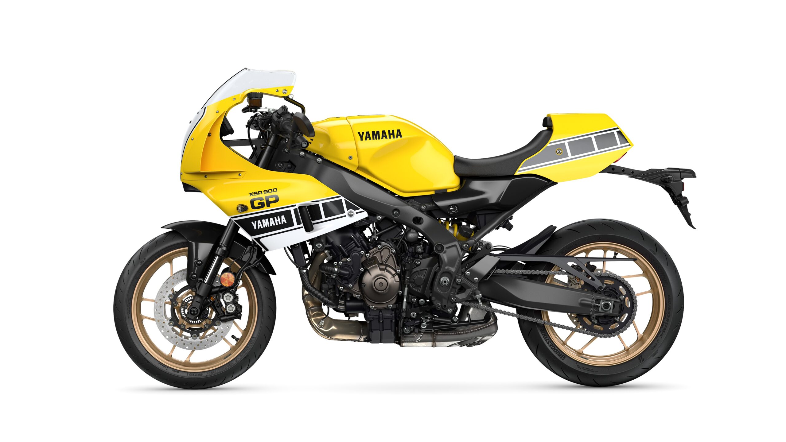 Yamaha 2026 XSR900 GP Legend Yellow - Left A yellow and black Yamaha XSR900 GP motorcycle in a side view, showcasing its sporty design, distinctive graphics, and gold alloy wheels.