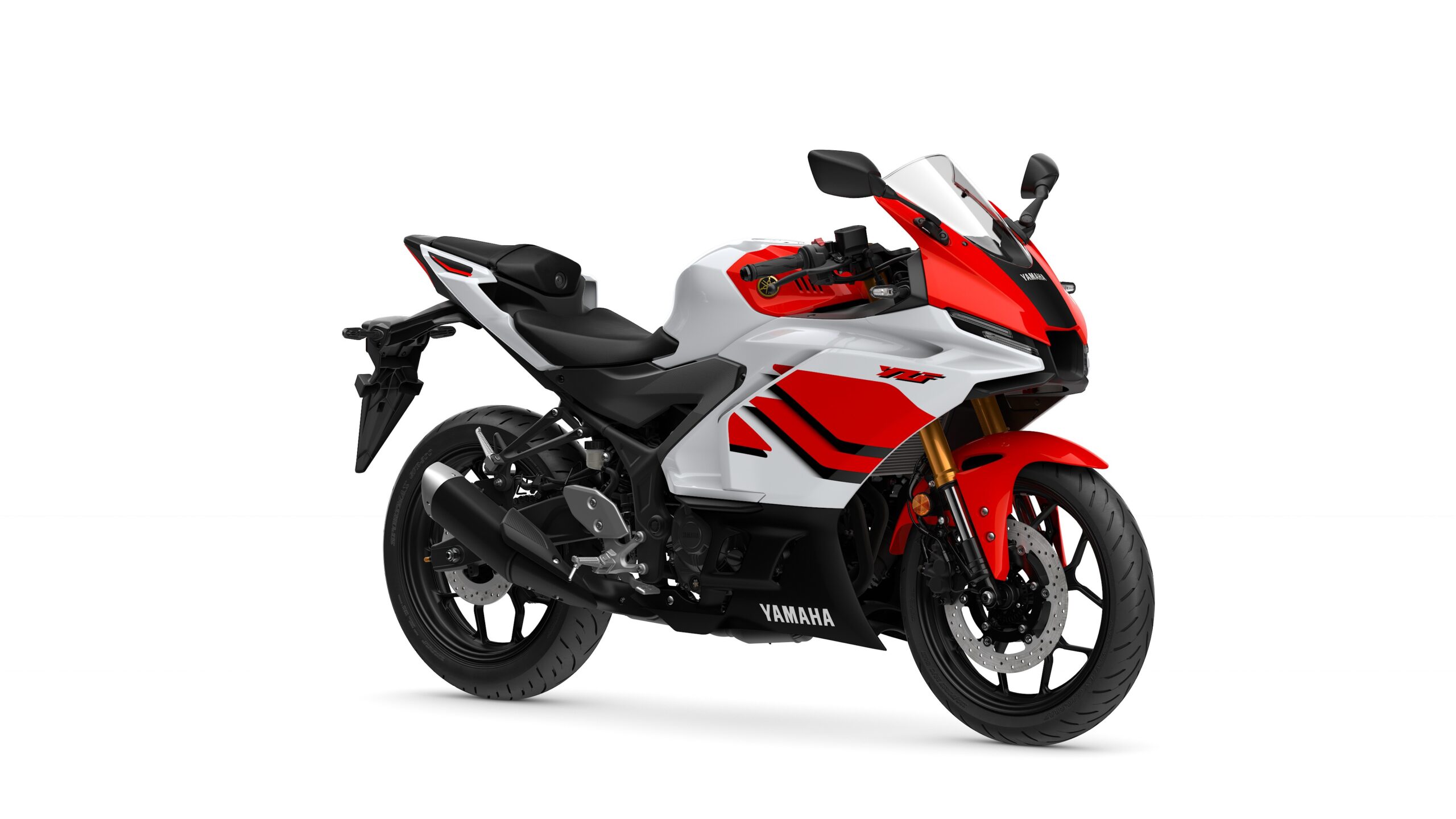 2026 Yamaha R3 Anniversary Edition Lateral Right A sleek, modern Yamaha motorcycle with a white and red color scheme, featuring sport bike styling, a fairing, and a prominent front headlight.