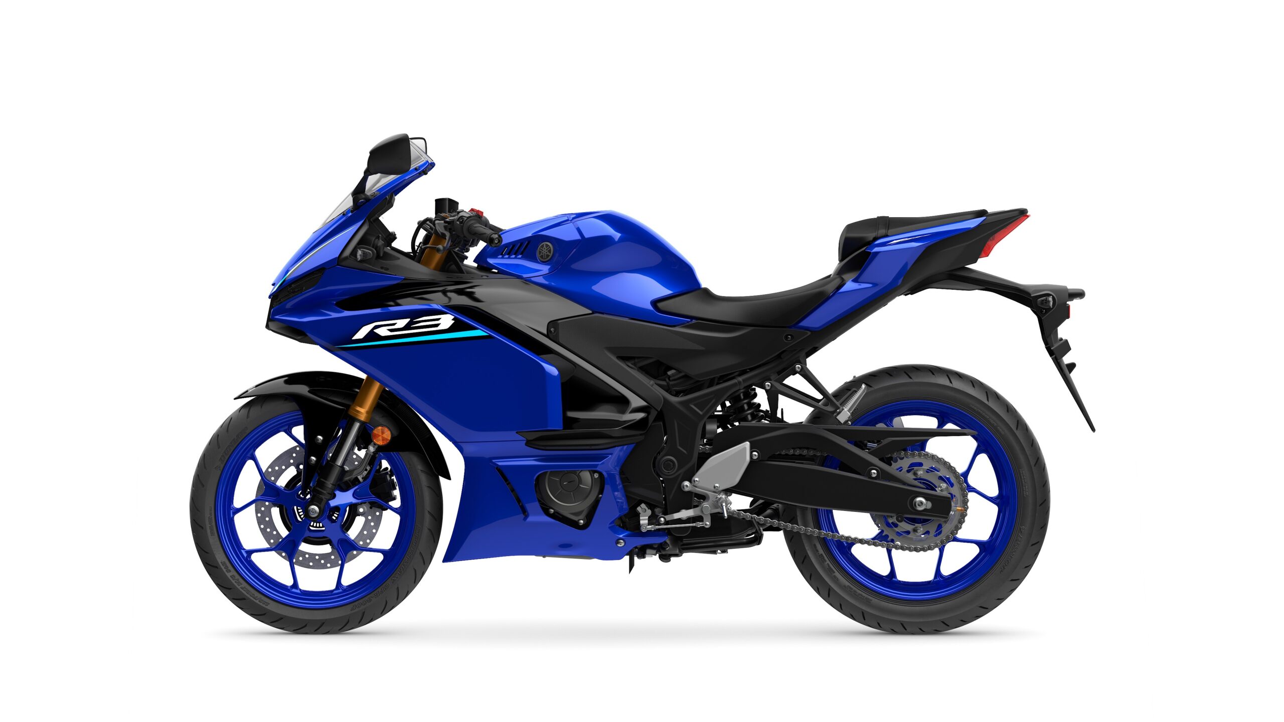 2026 Yamaha R3 Icon Blue Left A blue sports motorcycle, Yamaha YZF-R3, shown in profile with a sleek design, sporty fairings, and distinctive blue wheels.