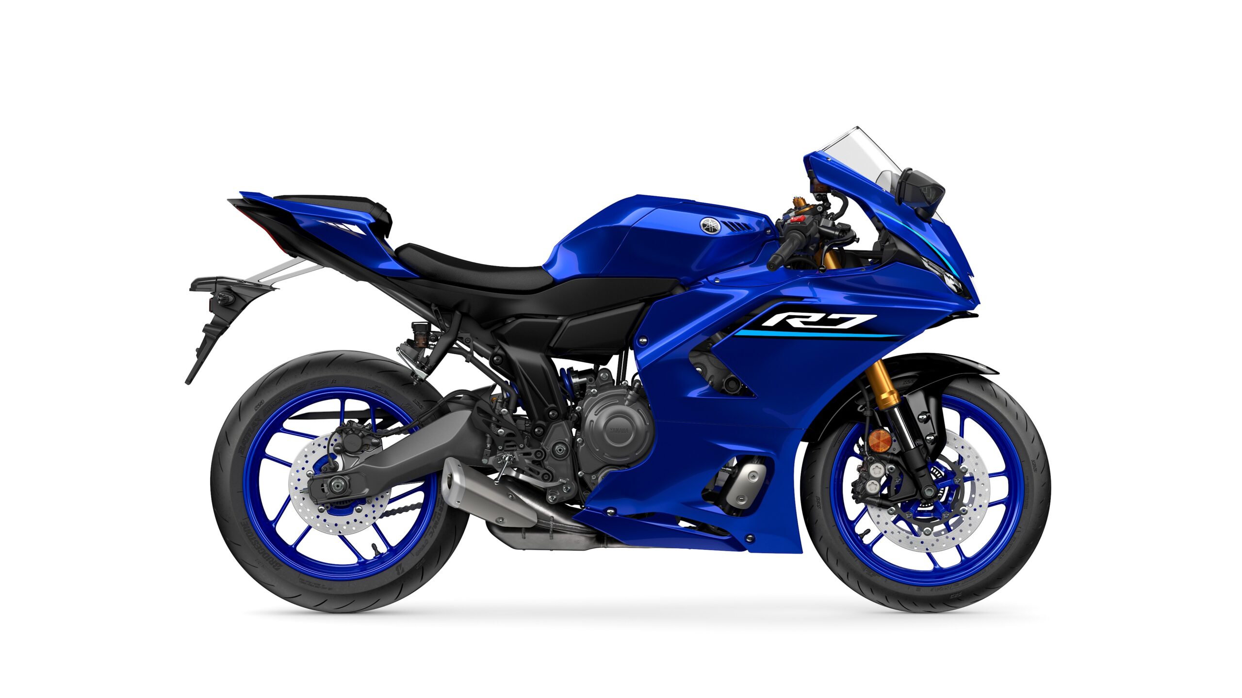 2026 Yamaha R7 Icon Blue Right A sleek blue Yamaha R7 motorcycle viewed from the side, showcasing its aerodynamic design, sporty frame, and distinct blue accents on the wheels.