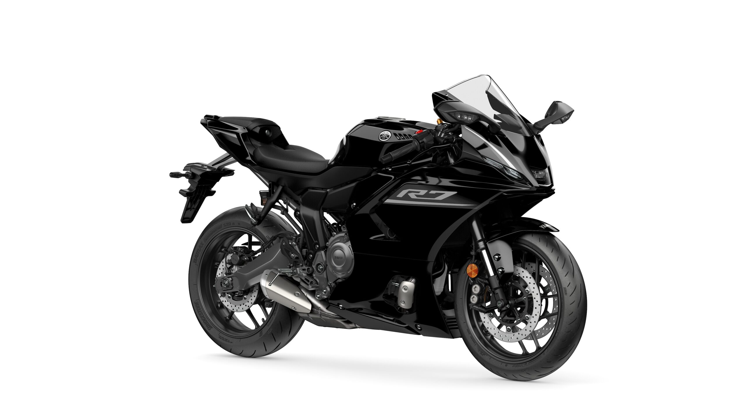 2026 Yamaha R7 Midnight Black Lateral Right A sleek black motorcycle, model R7, stands on a white background, showcasing its aerodynamic design, sports seat, and modern styling.