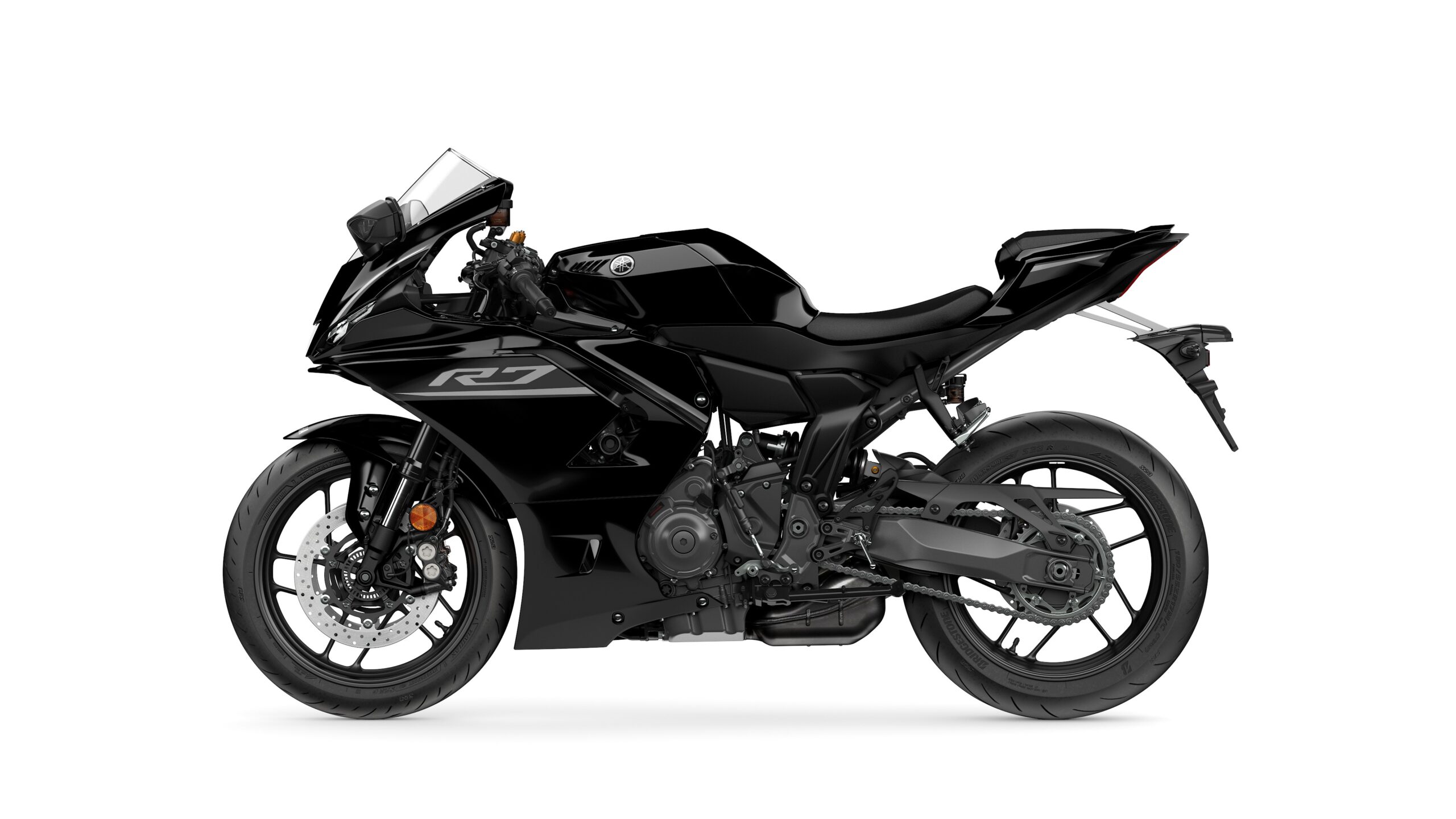 2026 Yamaha R7 Midnight Black Left A sleek black Yamaha YZF-R7 motorcycle viewed from the side, showcasing its sporty design, low profile, and modern features.