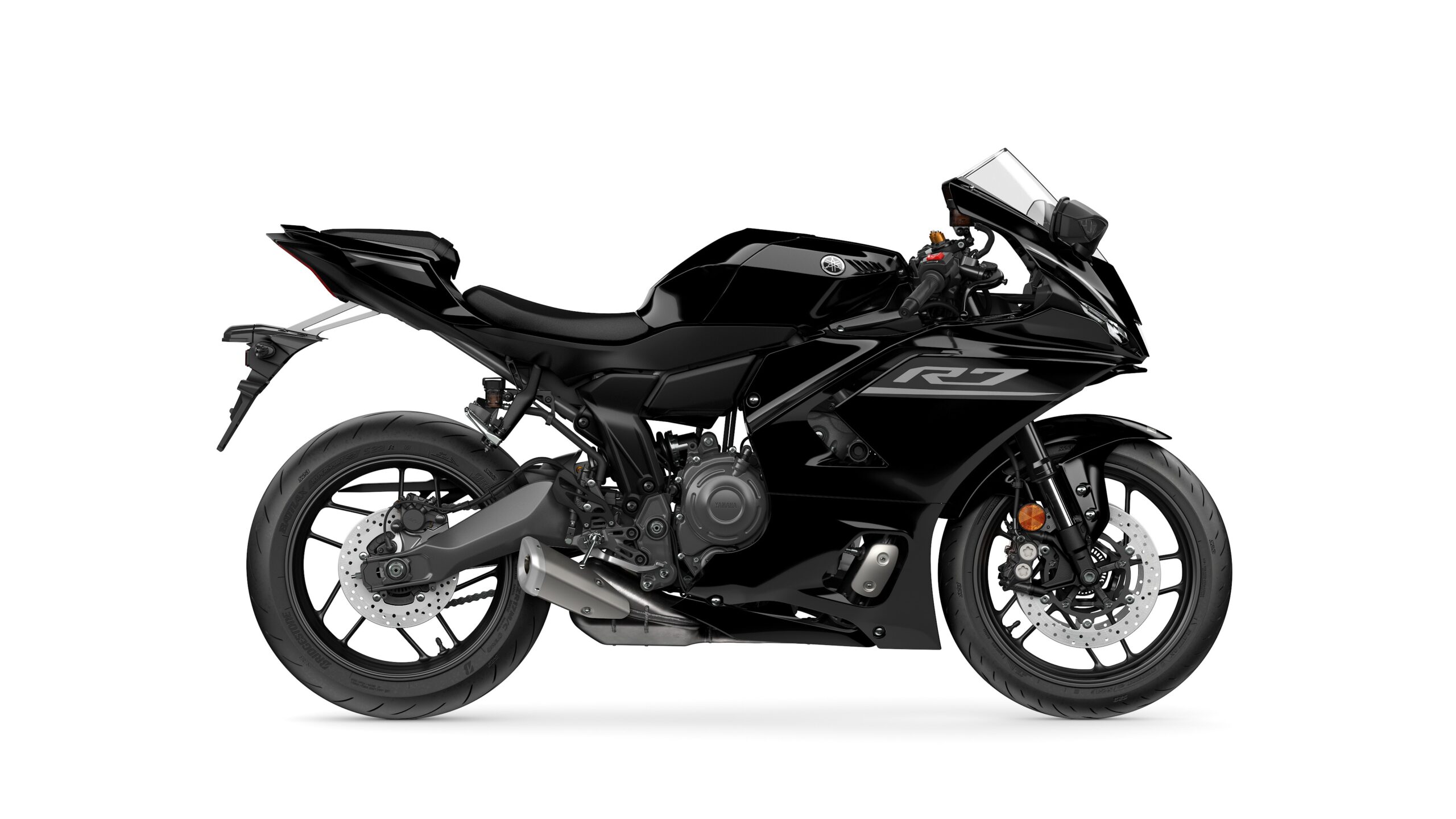 2026 Yamaha R7 Midnight Black Right A sleek black sport motorcycle with a streamlined design, featuring a prominent R7 logo, sport fairings, dual front headlights, and a single exhaust on the right side.