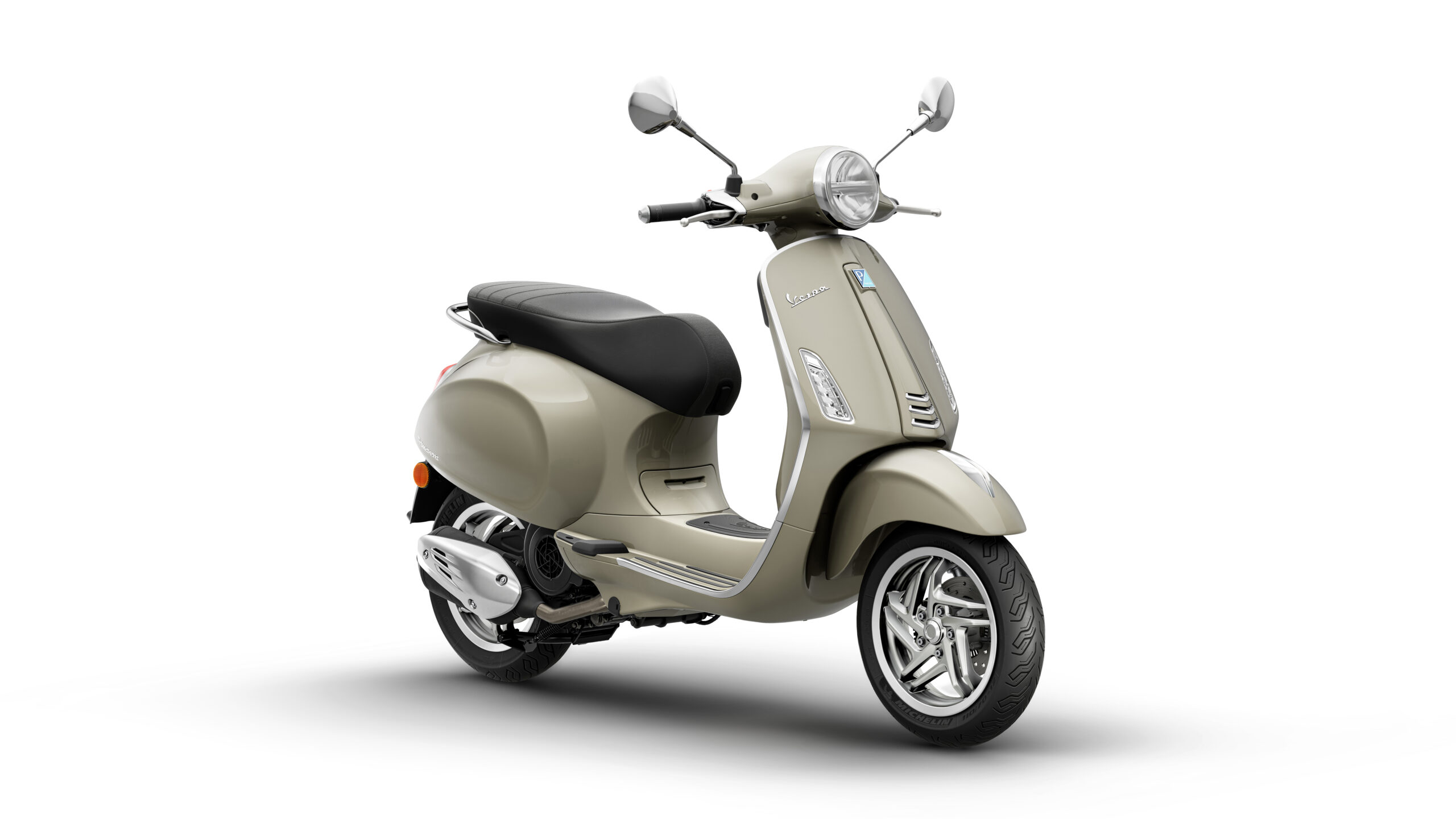 Primavera 125 2026 Beige Avvolgente Lateral Right A vintage-style beige scooter, angled to show its sleek design, black seat, and chrome accents, set against a white background.