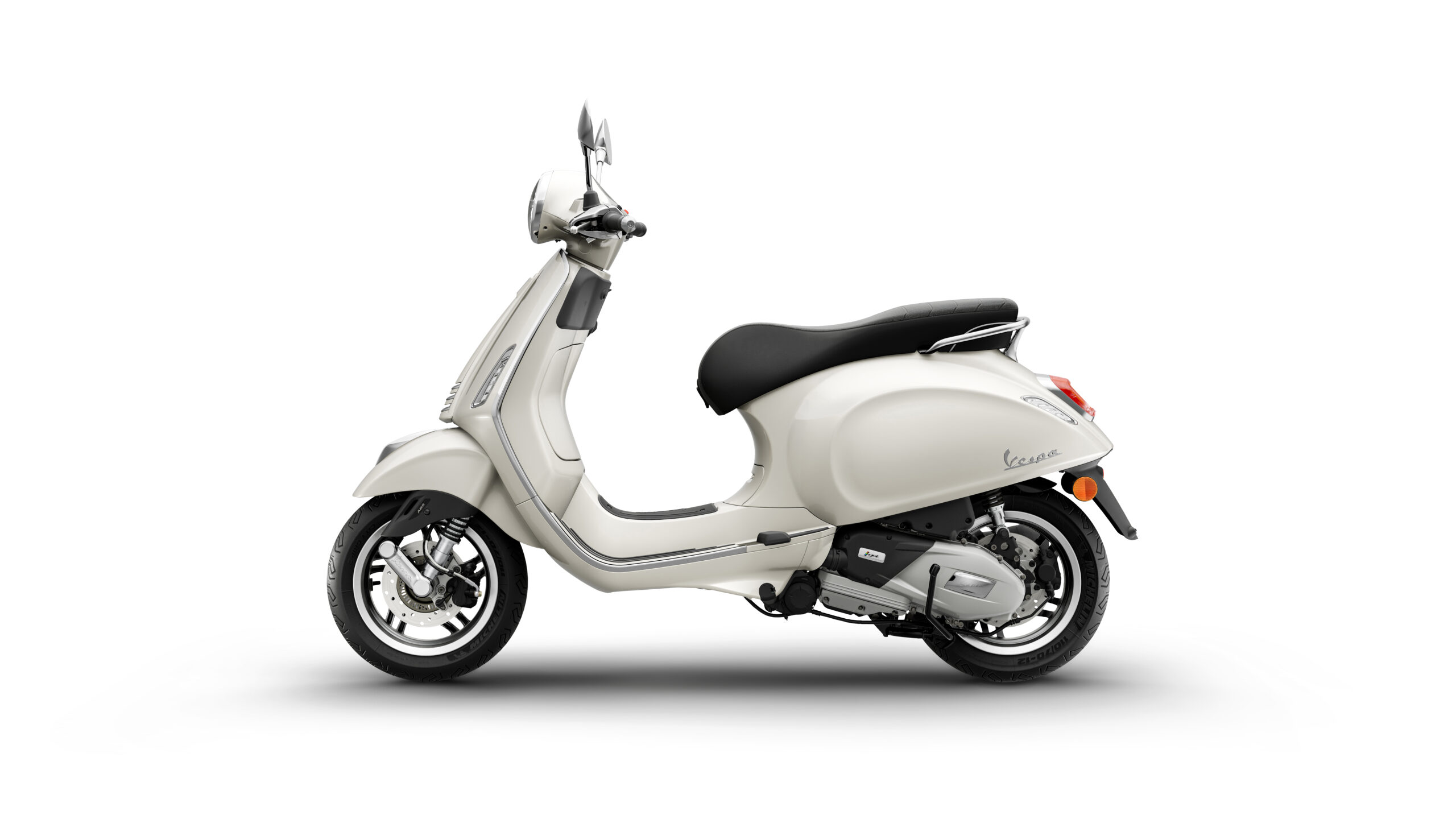 Primavera 125 2026 Bianco Innocente Left A light-colored scooter in profile view, featuring a comfortable black seat, chrome details, and modern design elements. The scooter is positioned on a minimalist background.