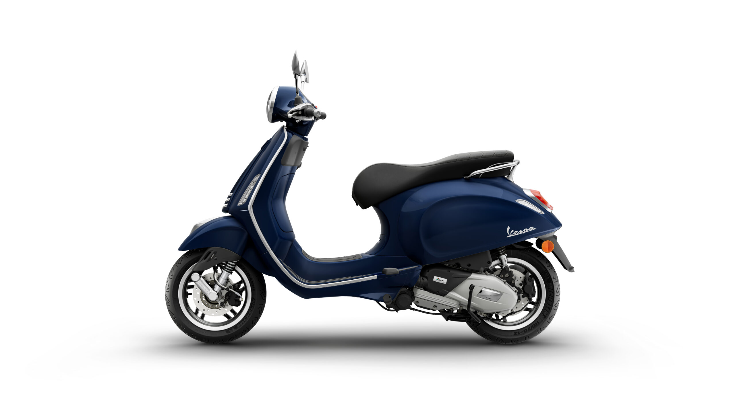 Primavera 125 2026 Blu Energico Left A blue Vespa scooter viewed from the side, showcasing its sleek design and chrome accents against a plain white background.