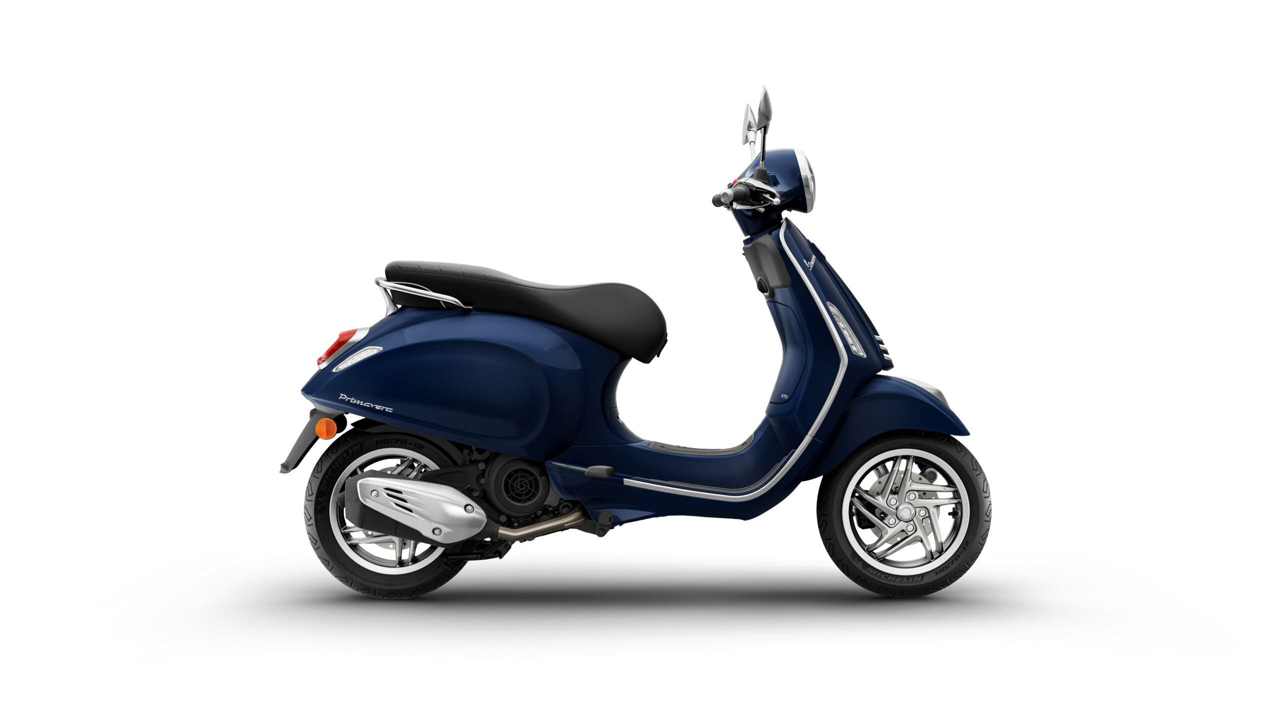 Primavera 125 2026 Blu Energico Right A sleek blue scooter with a comfortable black seat, showcasing a chrome-plated exhaust and stylish wheels, positioned on a white background.