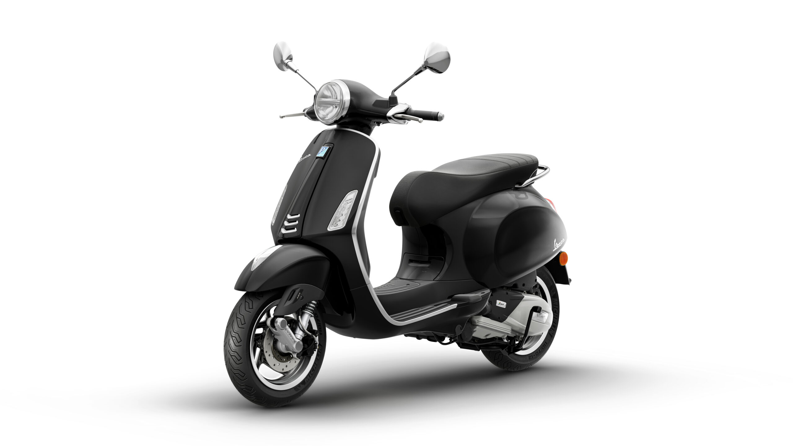 Primavera 125 2026 Nero Convinto Lateral Left A sleek black scooter with a vintage design, featuring a round headlight, chrome accents, and a comfortable seat, positioned at a slight angle against a white background.