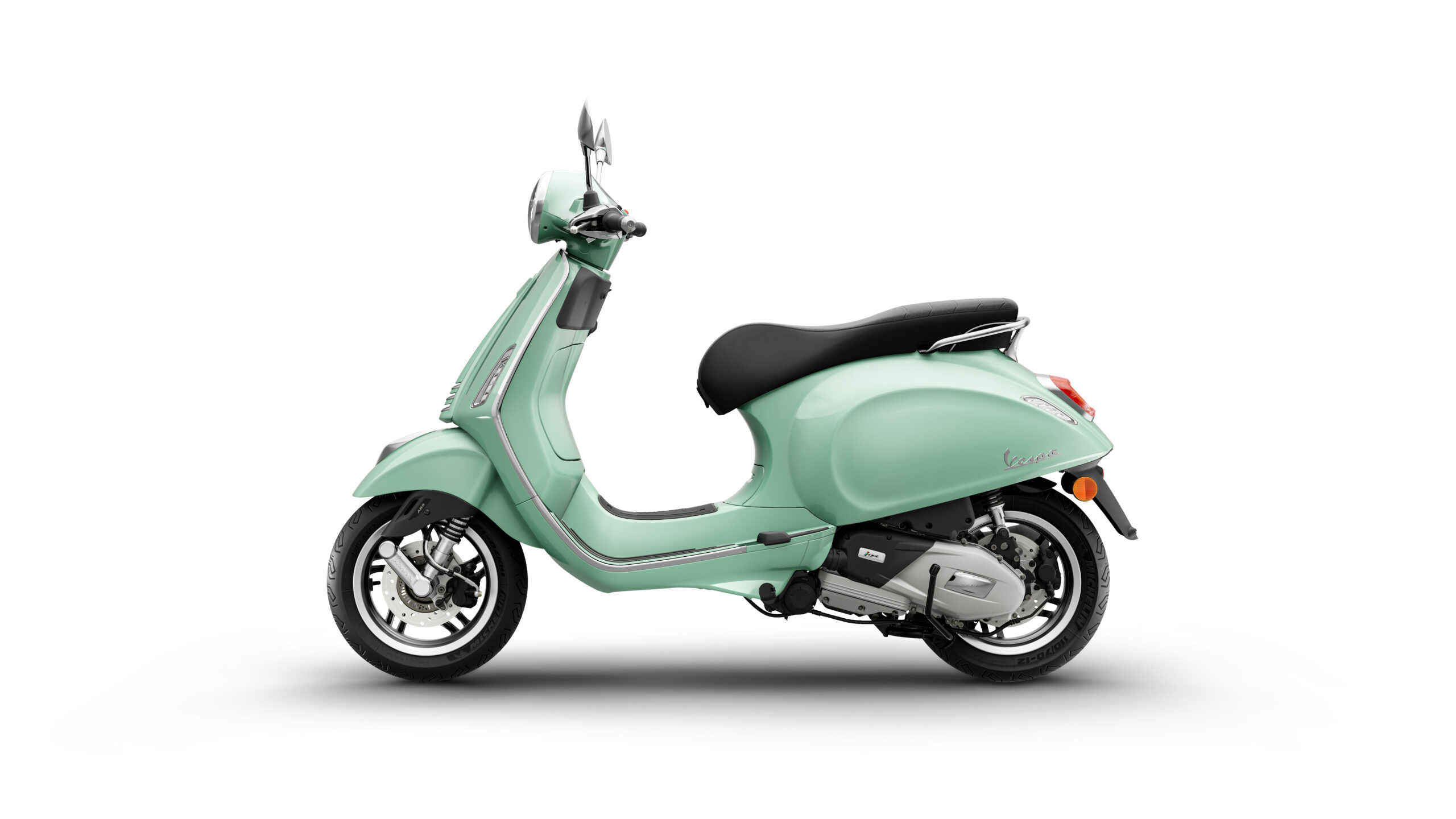 Primavera 125 2026 Verde Amabile Left A mint green scooter with a sleek design, featuring a black seat, chrome accents, and a distinctive front light, positioned against a white background.