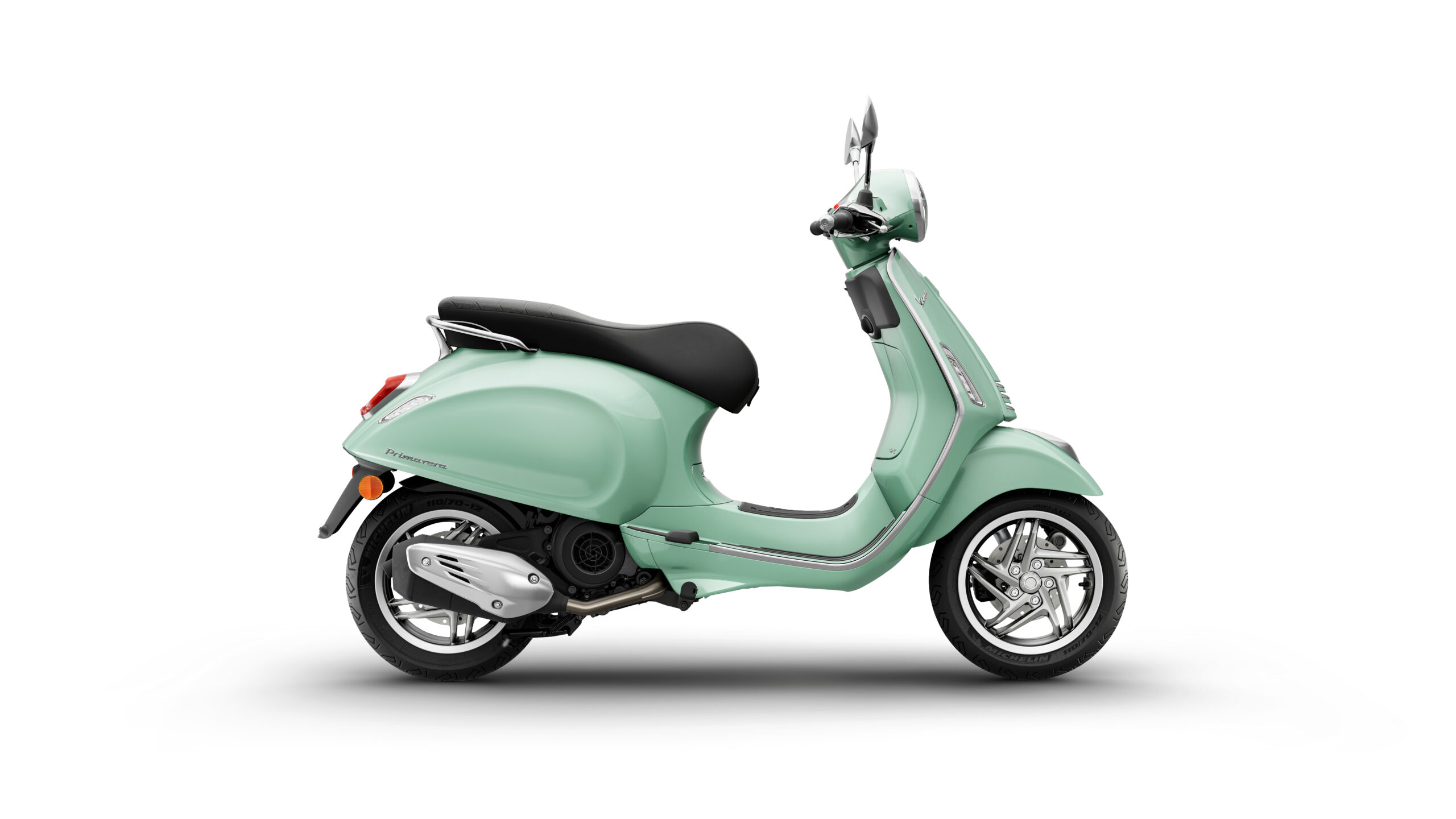 Primavera 125 2026 Verde Amabile Right A mint green scooter with a black seat, shown in profile against a white background. The scooter features chrome accents, a round headlight, and stylish wheels.