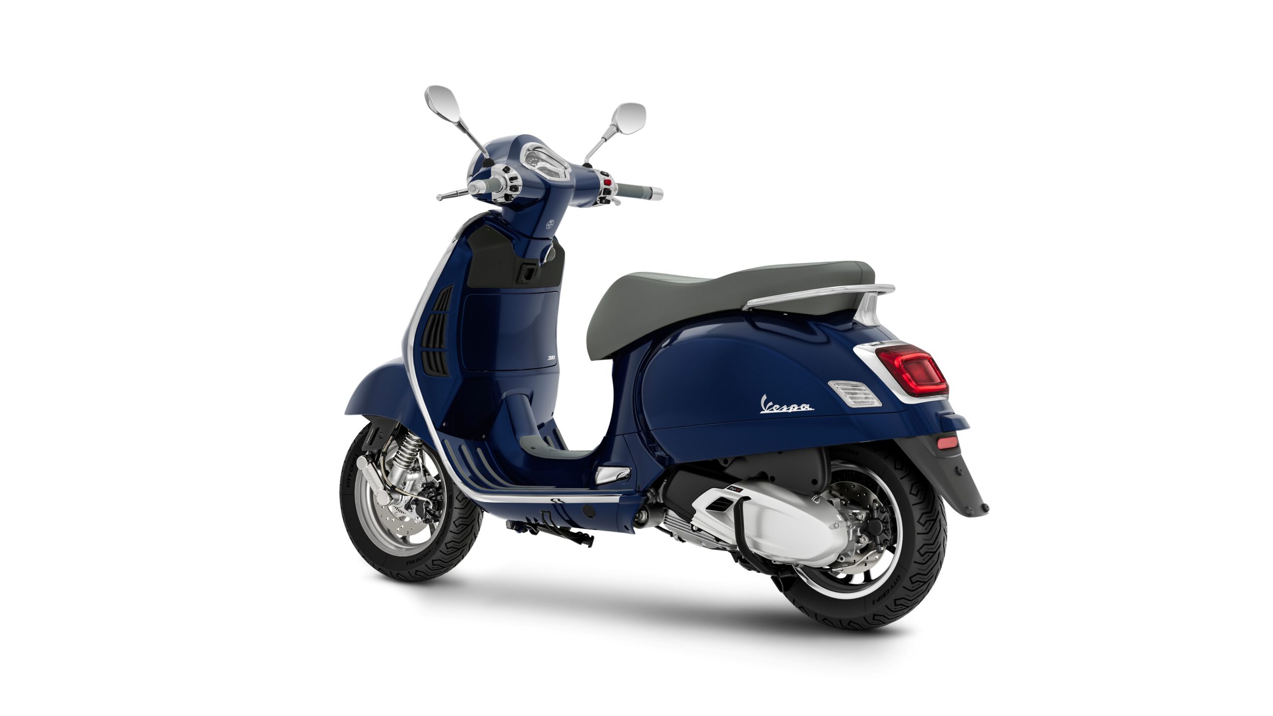 Vespa GTS 310 2026 Blu Energico Lateral Left Rear A blue Vespa scooter viewed from the rear, showcasing its sleek design, chrome details, and smooth lines against a white background.