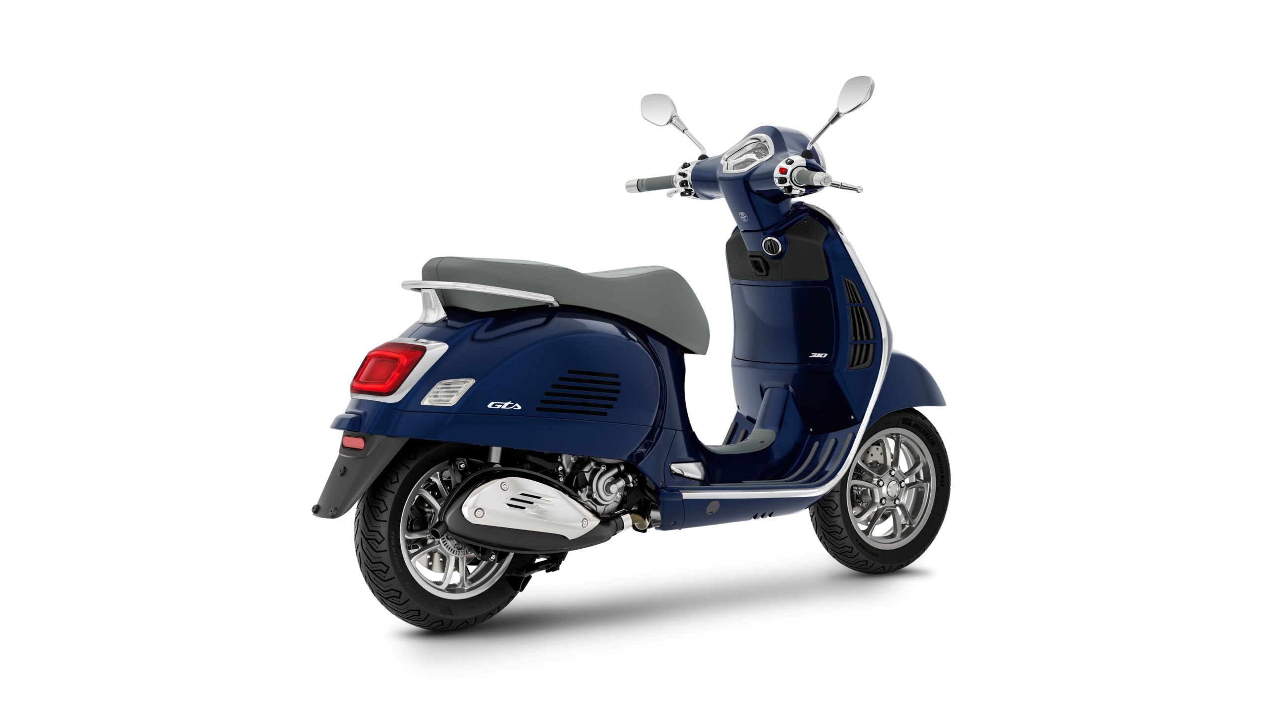 Vespa GTS 310 2026 Blu Energico Lateral Right Rear A blue Vespa scooter with a gray seat, viewed from the rear-left angle, showcasing its sleek design and chrome accents.