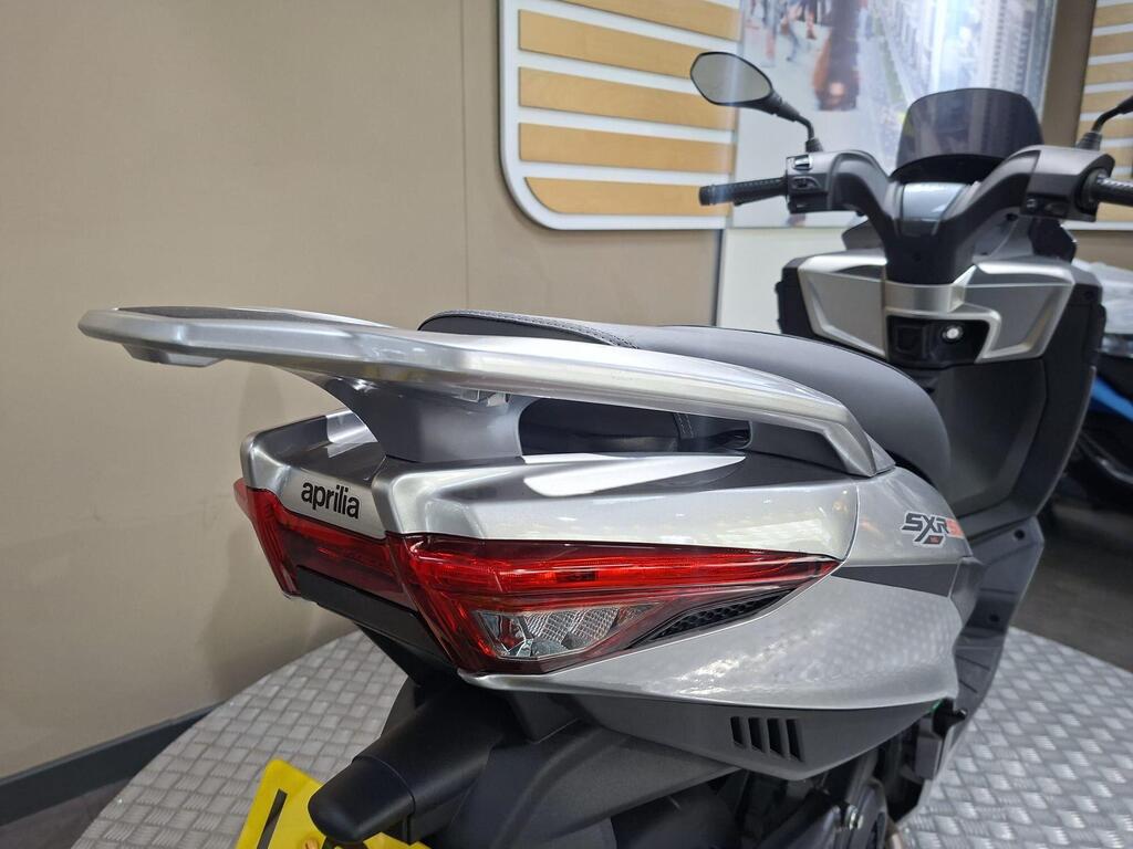 Aprilia SXR 50 2026 14 Close-up of a rearview of a silver Aprilia scooter, highlighting its sleek tail section and integrated taillights.