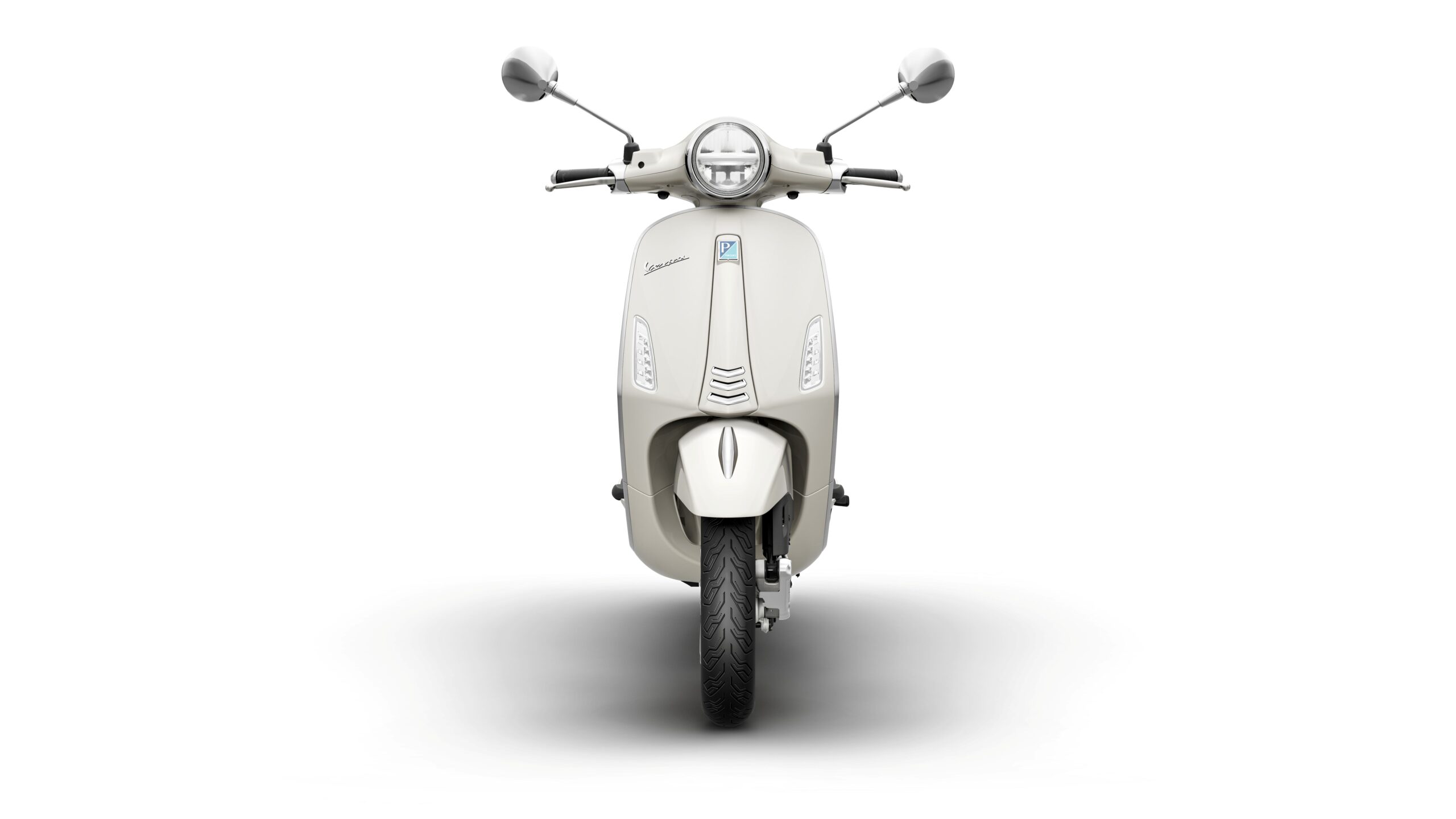 Vespa Primavera 50 MY26 Bianco Innocente Front Front view of a cream-colored scooter with a sleek design, featuring round mirrors, a circular headlight, and a prominent logo. The scooter is set against a white background, highlighting its clean lines and modern aesthetics.
