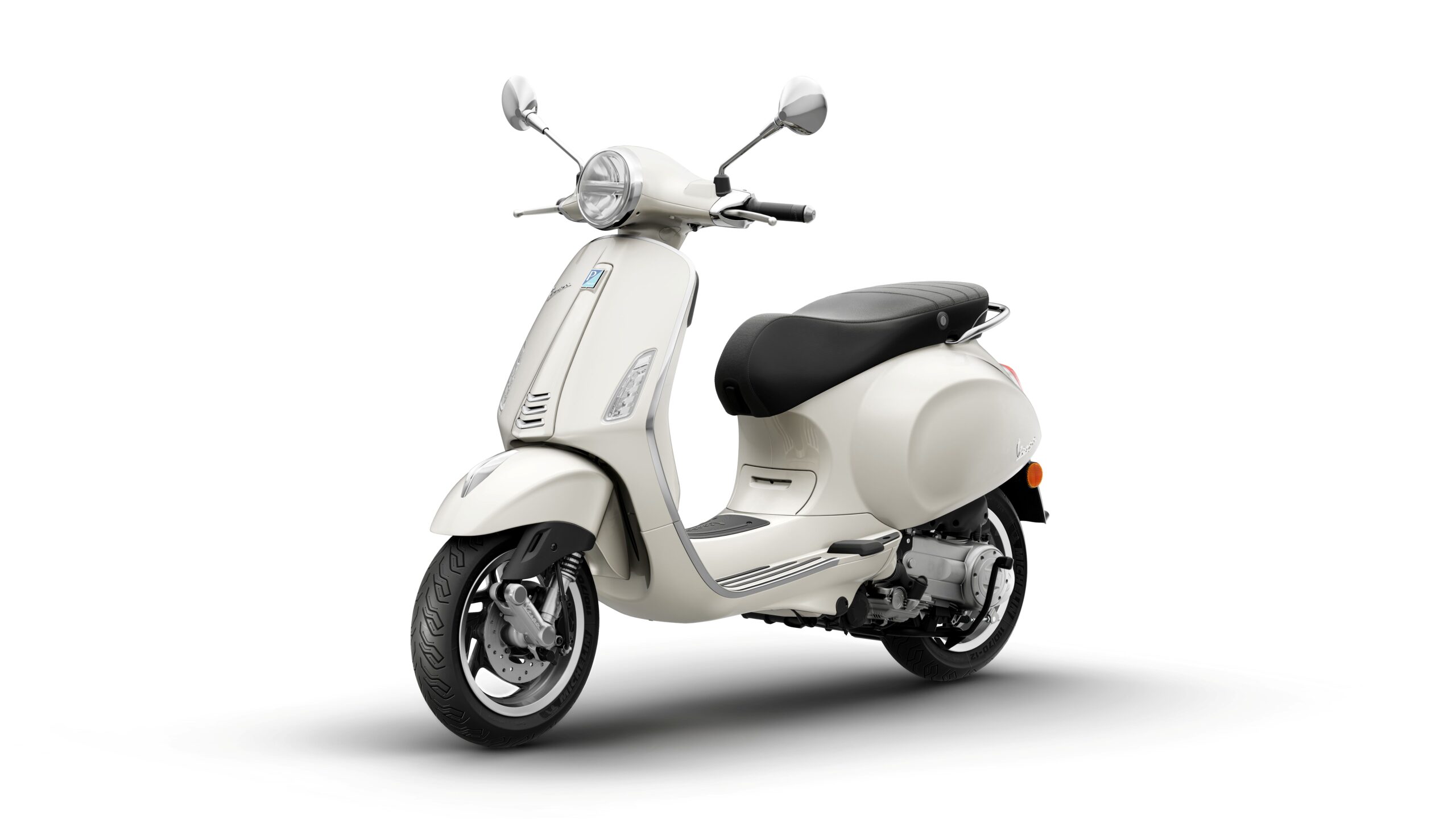 Vespa Primavera 50 MY26 Bianco Innocente Lateral Left A classic white scooter with a black seat, featuring a chrome front fender and mirrors, positioned against a plain white background.