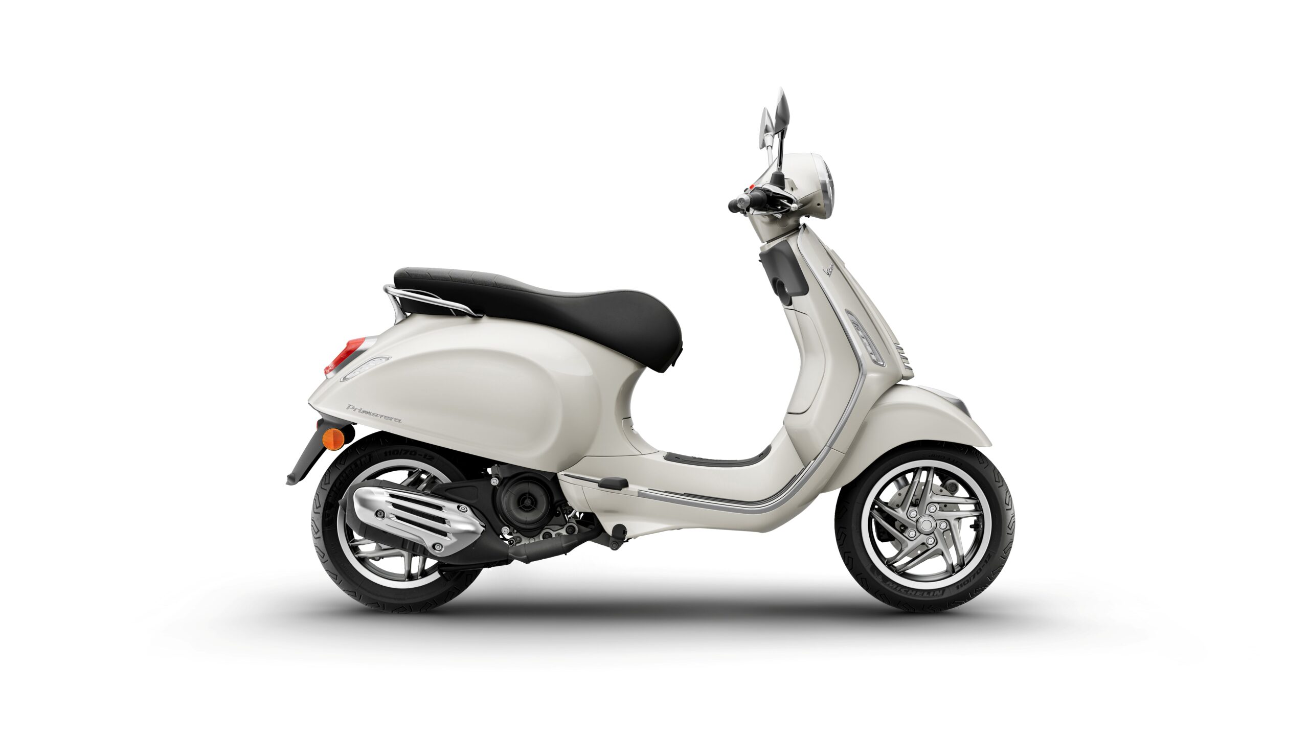Vespa Primavera 50 MY26 Bianco Innocente Right A sleek, light-colored scooter is shown in profile, featuring a rounded body, black seat, and shiny silver wheels, set against a plain white background.