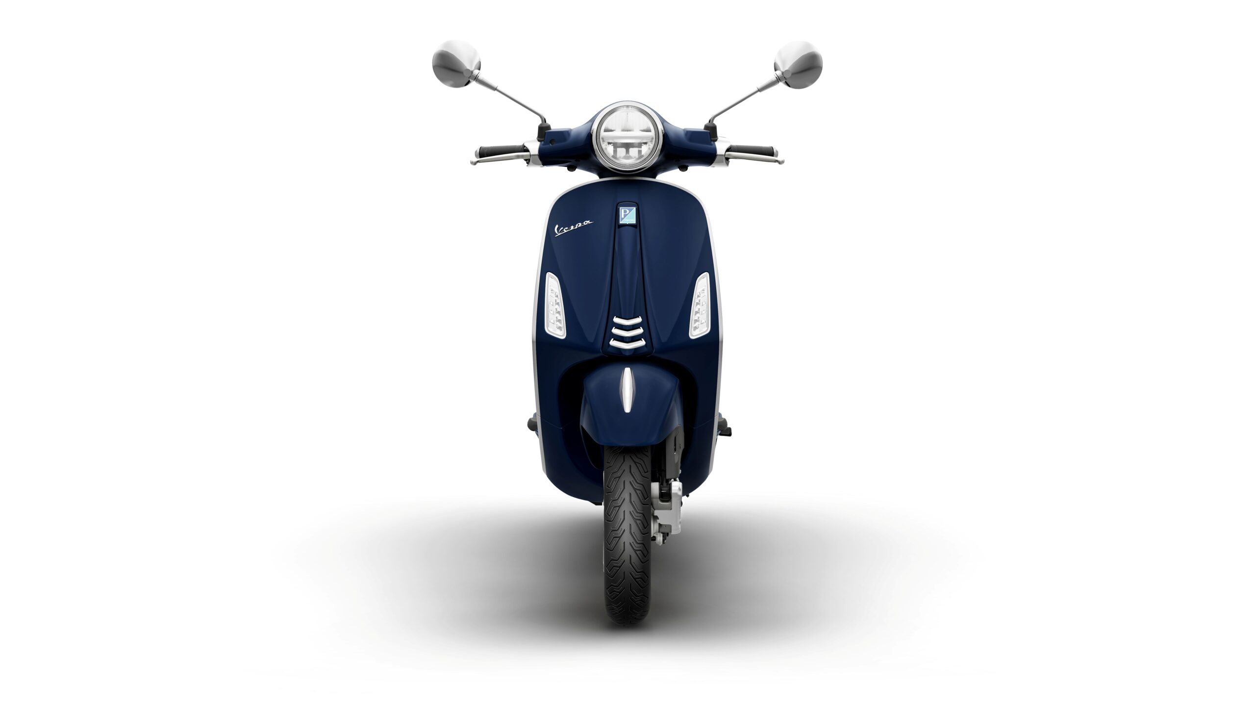 Vespa Primavera 50 MY26 Blue Energico Front A navy blue scooter with a rounded headlight and chrome rearview mirrors, facing front with a focused shadow beneath.