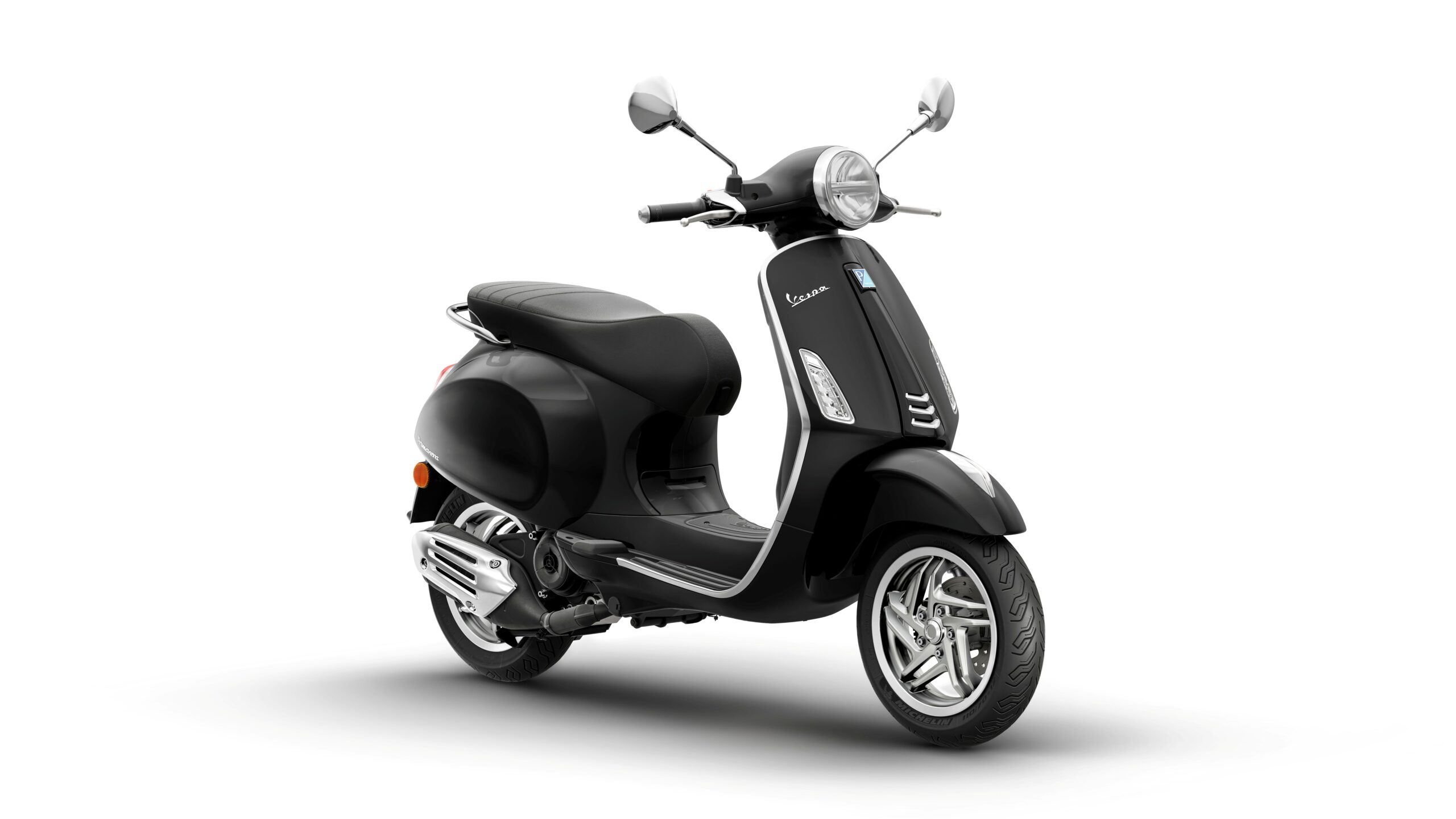 Vespa Primavera 50 MY26 Nero Convinto Lateral Right A sleek black Vespa scooter positioned at an angle, showcasing its smooth curves, chrome details, and stylish design.