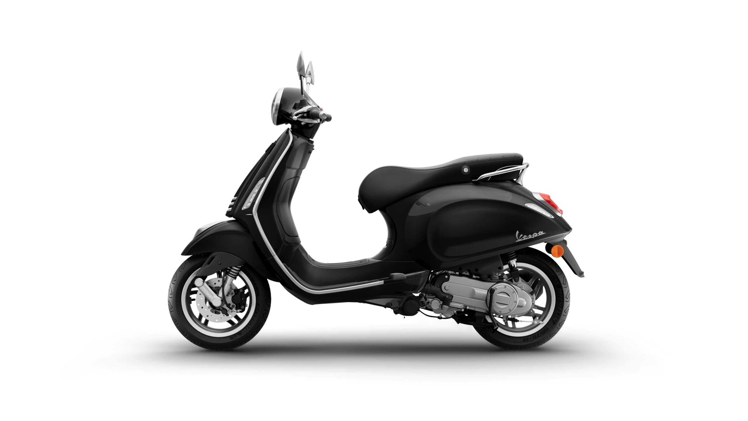Vespa Primavera 50 MY26 Nero Convinto Left A sleek black Vespa scooter is shown from the side, featuring a rounded body, single seat, and stylish chrome accents. The rear light and mirrors are visible, along with detailed wheels.