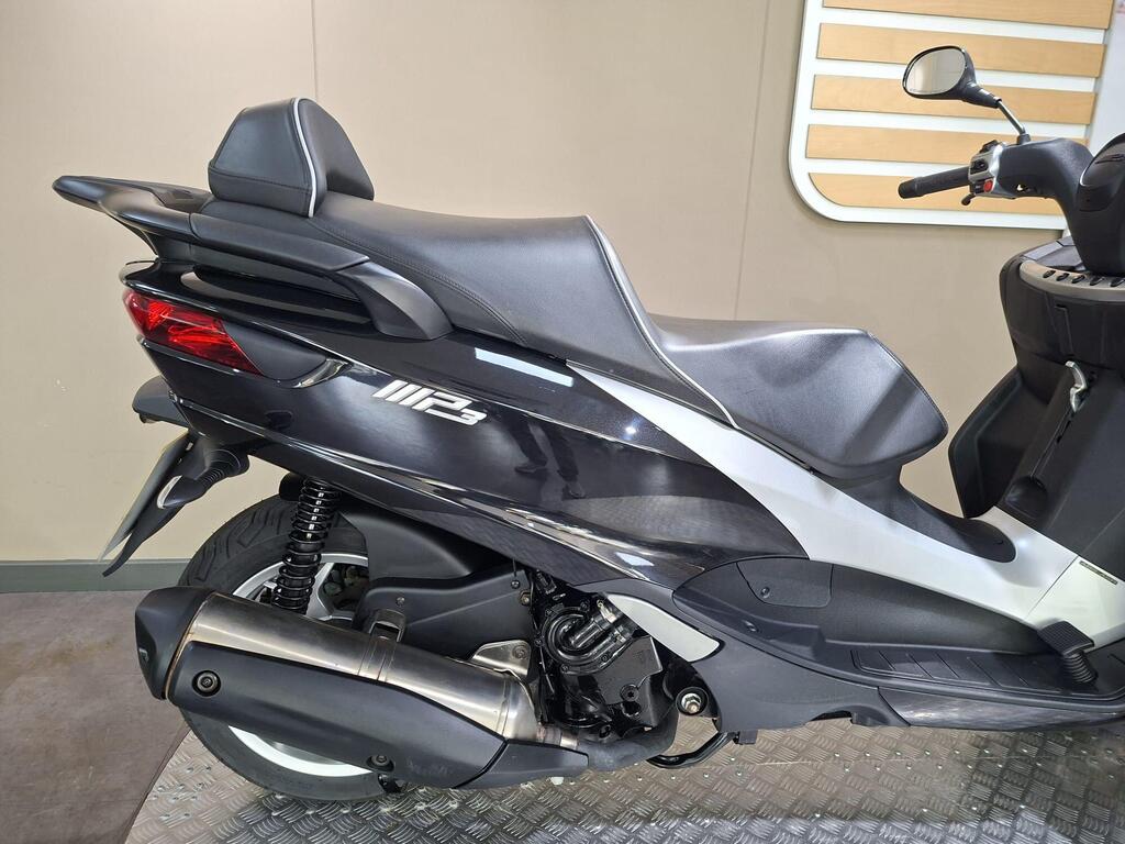 Piaggio MP3 500 Business 2021 18 A close-up view of the rear section of a modern scooter, featuring a sleek design, black and silver color scheme, and a visible exhaust pipe. The seat is contoured, and the scooter displays the model name "P3." The background is neutral, with a simple panel design.